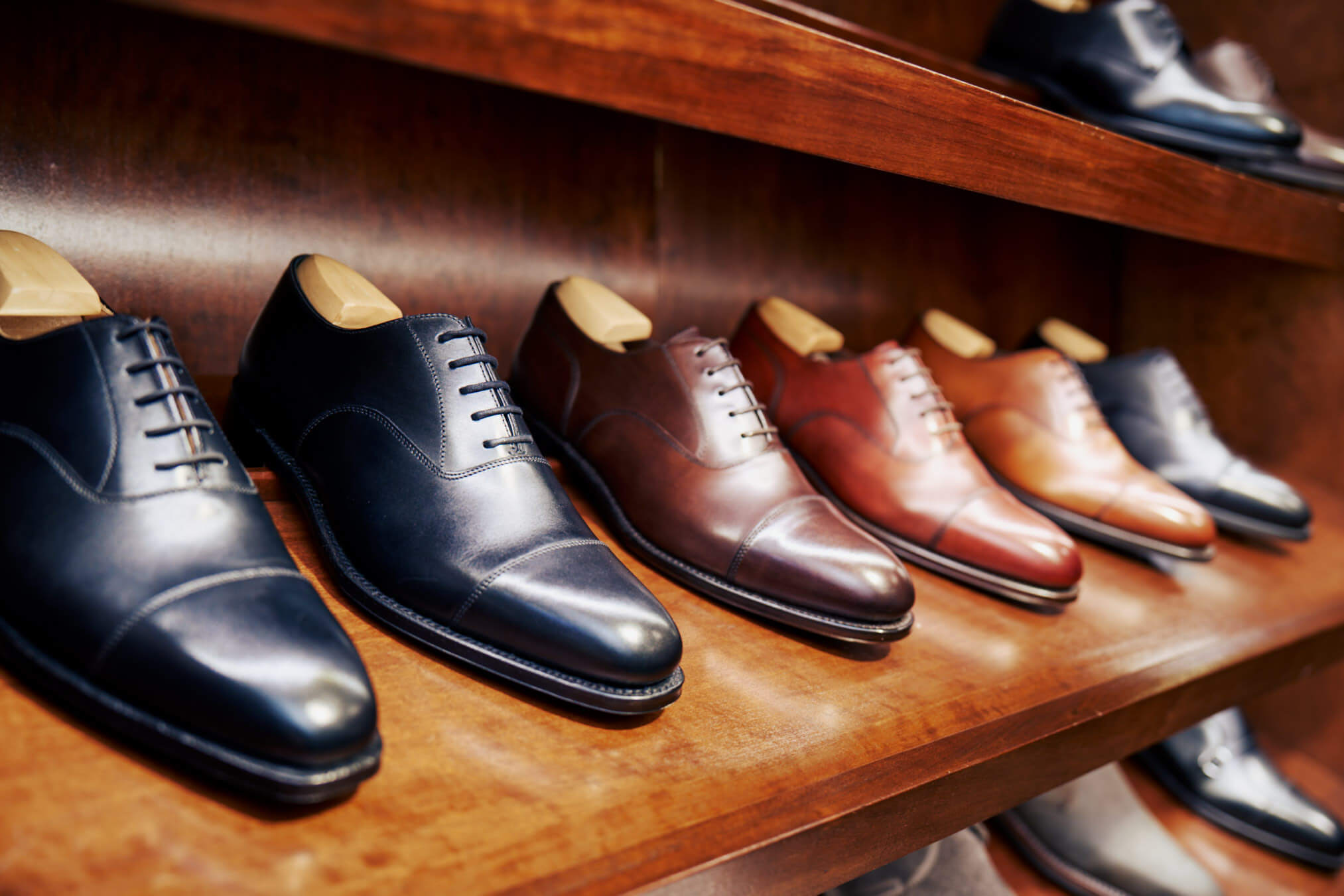 Selection of Oxford shoes displayed on a wooden shelf